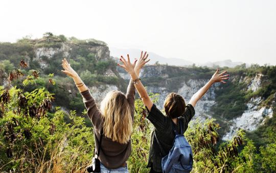 two women with backpacks and travel gear