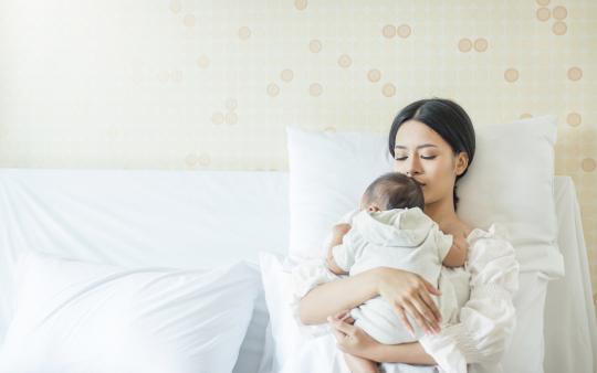 mother and new baby in bed