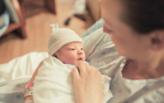 mom looking lovingly at newborn