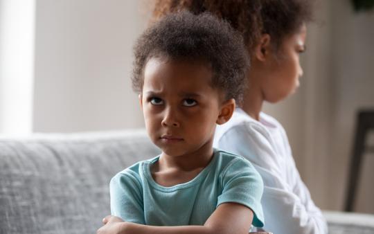 siblings looking angrily away from one another