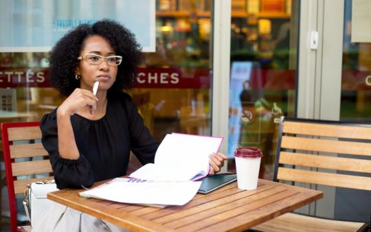 young woman looking thoughtful at the coffee shop