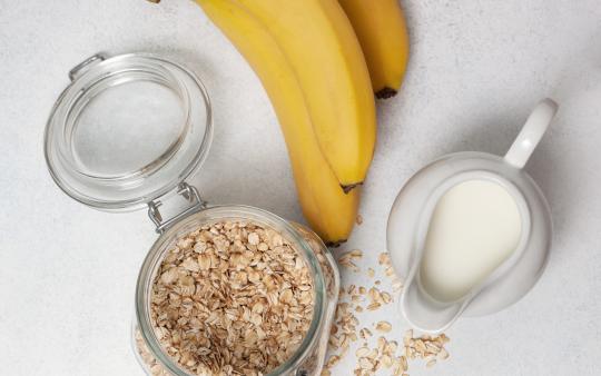 milk, oatmeal, bananas on a light background