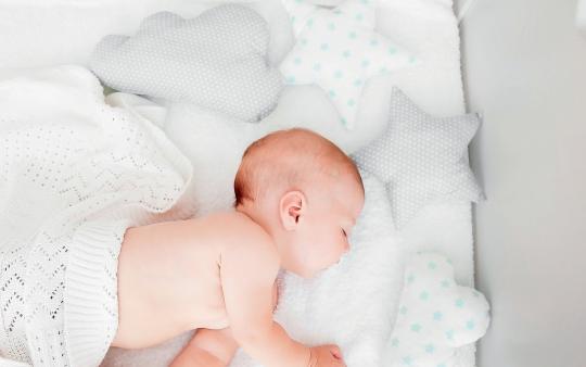 baby sleeping under white blanket