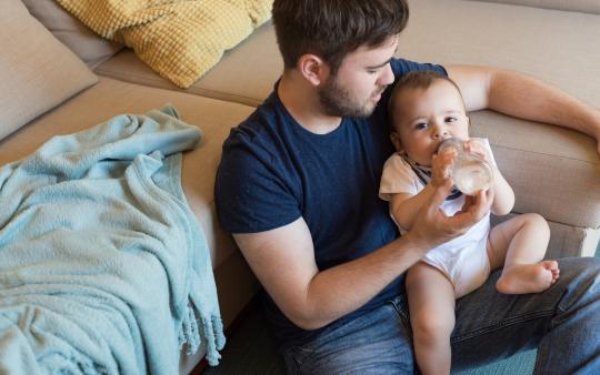 A father feeding his baby with a bottle 