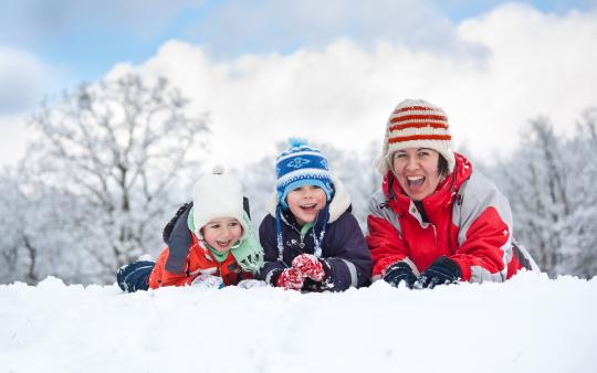 A family outside in the winter enjoying the sun and snow