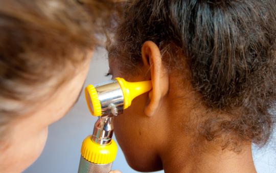 Doctor looking in a child's ear 