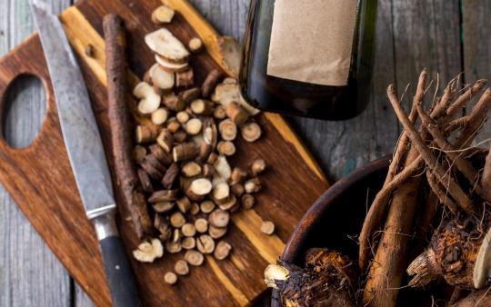 A chopped up root on a wooden cutting board.