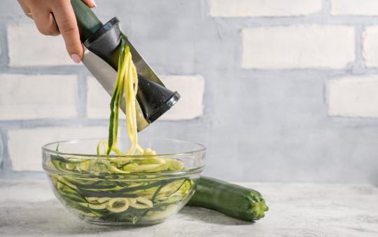 someone spiralizing zucchini into zucchini noodles