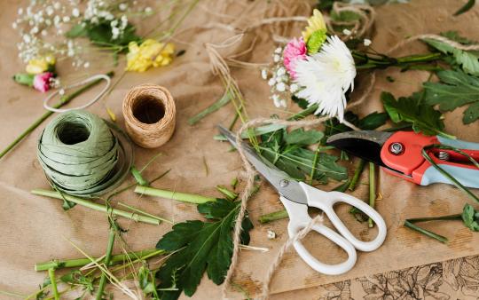 craft supplies and leaves laid out on brown paper