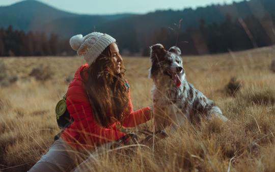 A woman in a field with a dog