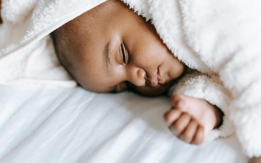 A baby sleeping on bedsheets