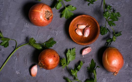 Onions and garlic along with herbs on a table