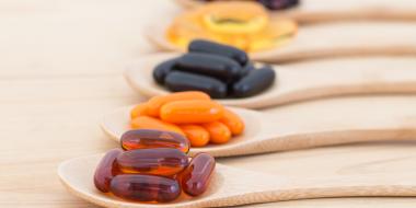 wooden spoons lined up and filled with various vitamins