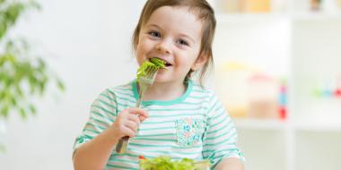 young child eating a healthy salad