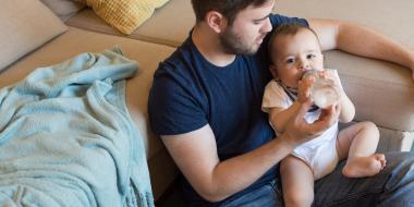 A father feeding his baby with a bottle 