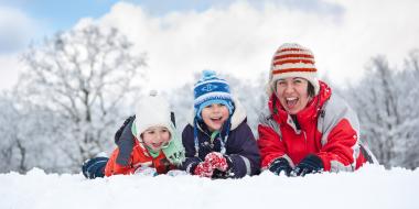 A family outside in the winter enjoying the sun and snow