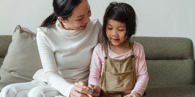 a mom guides her child in a drawing activity