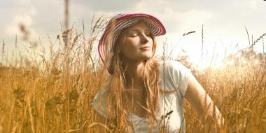 a woman in a sun hat in a field of wheat