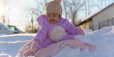 A smiling young child bundled up in winter clothes